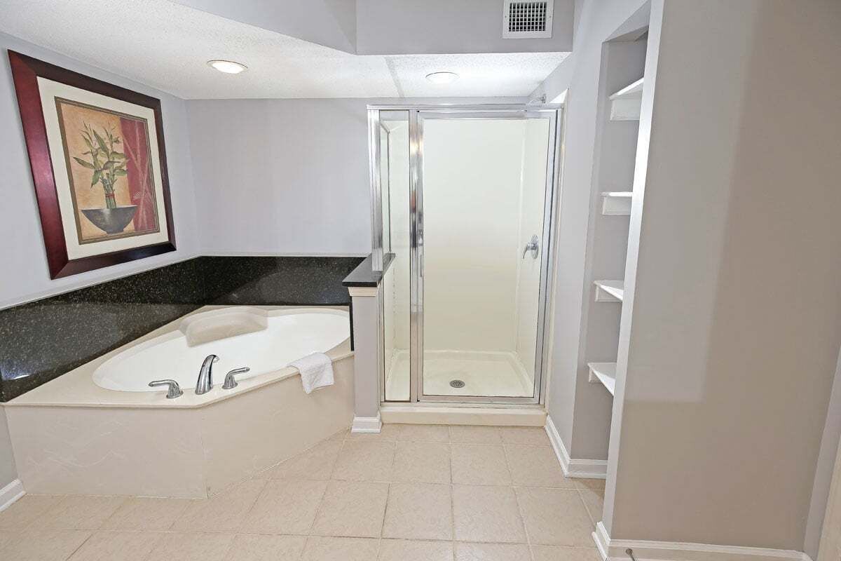 A bathroom with a bathtub, a shower enclosure, and a sink.