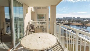 A balcony with a round table and chairs, overlooking a river and cityscape. - Yacht Club 1-1103 (North Myrtle Beach)