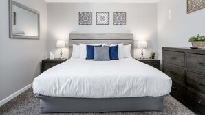 A bedroom with a bed, two bedside tables, a dresser, a ceiling fan, and three wall-mounted decorative items. - 126 Manning Mill Adairsville (Adairsville)