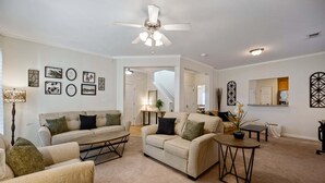 A spacious living room with a ceiling fan, a sofa set, a coffee table, and a dining table. - 4632 Liberty Square Dr, Acworth (Acworth)