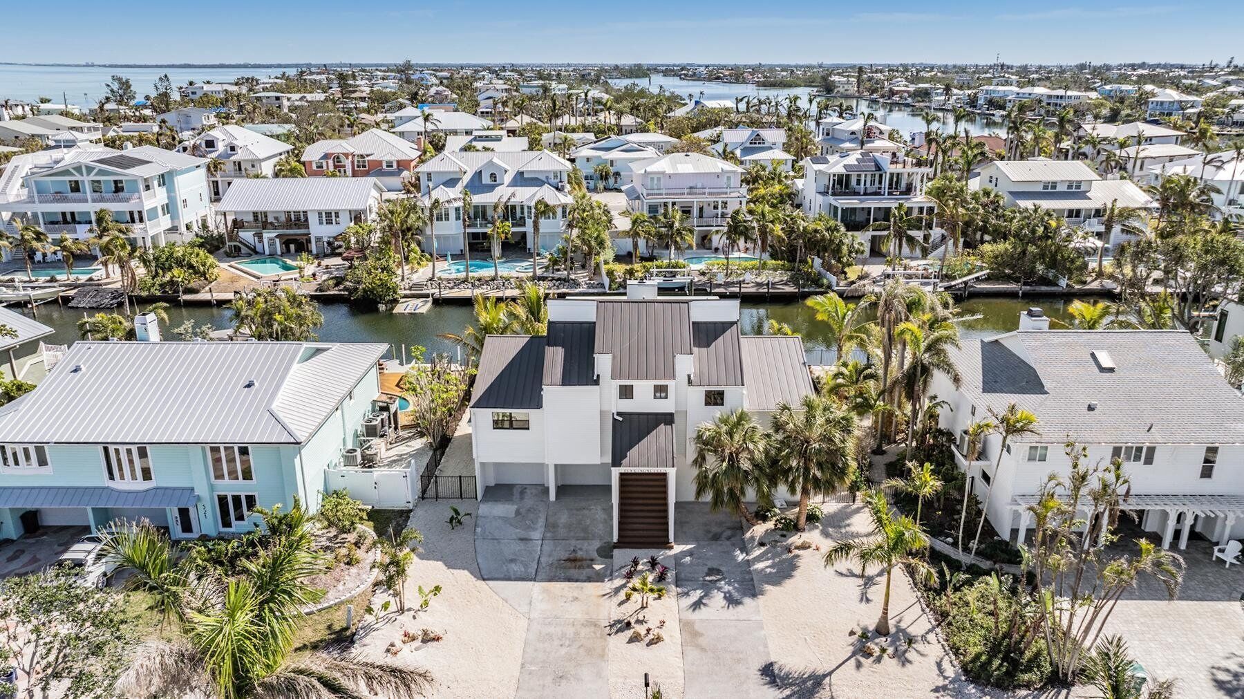 A coastal residential area with houses, a central building with a modern design, and a marina with boats.