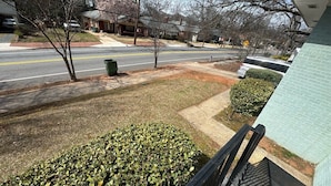 A residential street with houses, a sidewalk, and a grassy area with bushes. - Group-ready West End Duplex - Save Big Midweek (Atlanta)