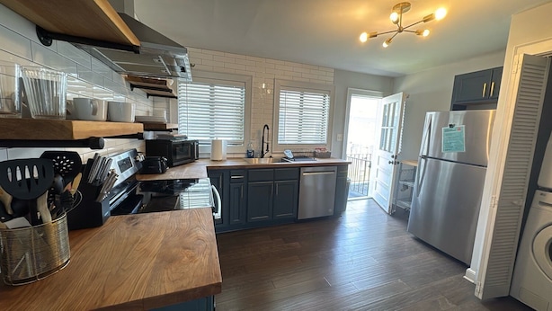 A modern kitchen with wooden countertops, stainless steel appliances, and a built-in oven. - Group-ready West End Duplex - Save Big Midweek (Atlanta)
