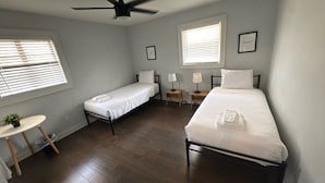 A room with two single beds, a ceiling fan, and two windows with blinds. - Group-ready West End Duplex - Save Big Midweek (Atlanta)