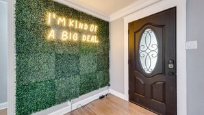 A wall with a green foliage wall and a neon sign that reads "I'M KIND OF A BIG DEAL". - Rare Exclusive Retreat Private Hot Tub King Bed (Arlington)