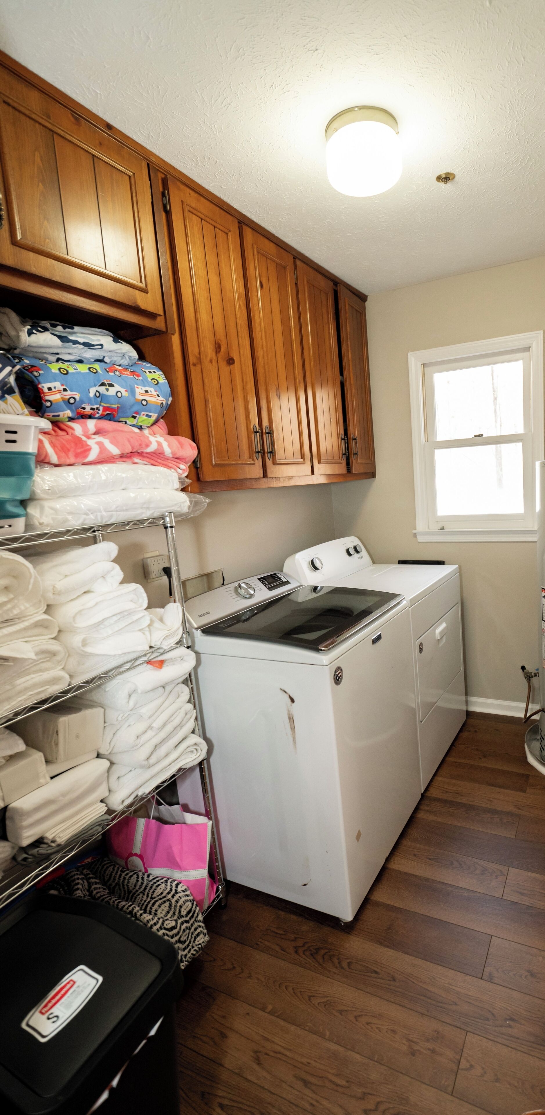 A laundry room with wooden cabinets, a washing machine, and a dryer.
