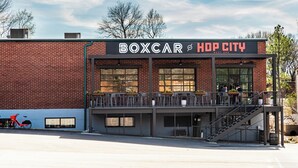Een gebouw met een bord waarop 'BOXCAR at HOP CITY WEST END' staat.