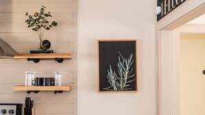 Een keuken met houten planken, een lijst met een botanische tekening en een welkomstbord.