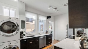 A modern kitchen with built-in appliances, a large window, and a view of the outside. - Standish House by BCA Furnished Apartments Standish House (Atlanta)