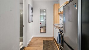 Eine moderne Küche mit Kühlschrank, Backofen und Holzschränken.