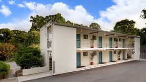 A two-story motel with a flat roof, multiple balconies, and potted plants. - Studios On 25th by BCA Furnished Apartments Studio 05 E (Atlanta)