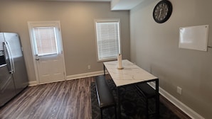 A kitchen with a refrigerator, two windows with blinds, a marble countertop, and a clock on the wall. - Legacy Executive Retreat (Clarksville)