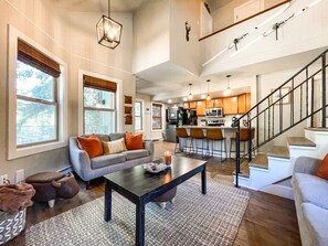A spacious living area with a sofa, coffee table, and a staircase leading to an upper floor. - 193 Range (Breckenridge)