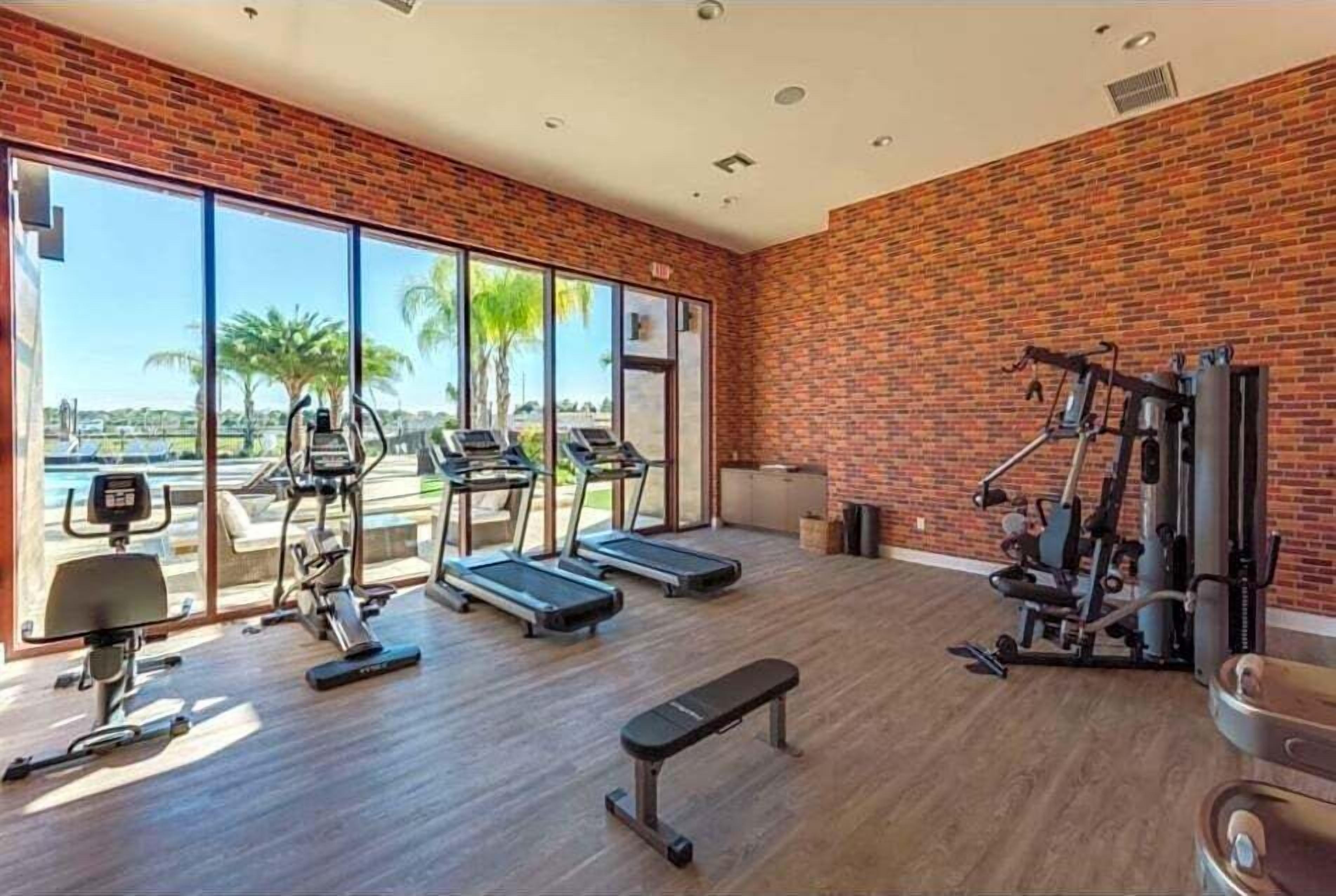 A gym with treadmills, exercise bikes, and weight machines.