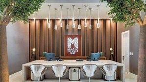 Una moderna zona de recepción con una mesa larga, cuatro sillas y un cartel que dice "MAGIC VILLAGE Resort".
