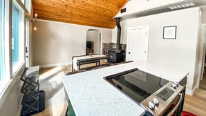 Una cucina moderna con una grande isola, un piano cottura integrato e una ventola a soffitto.