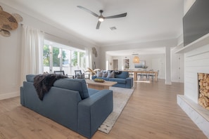 A spacious living room with a blue sofa, a wooden coffee table, and a ceiling fan. - 125 Harbor Bluff Dr (Largo)