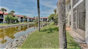 A row of modern buildings with a water canal in the foreground. - Runaway Bay (Bradenton Beach)