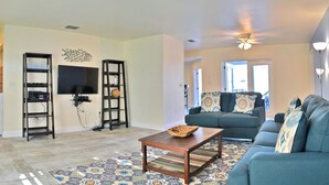 A living room with a sofa, a coffee table, a TV, and two shelves. - Desoto (Bradenton)