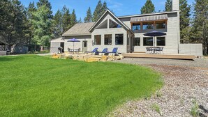 A modern two-story house with a large lawn, outdoor seating area, and a covered patio. - Aspen Place River Access & Ping Pong (Bend)