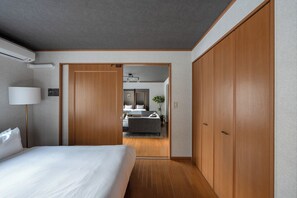 Une chambre d’hôtel avec un grand lit, une armoire en bois, une table de chevet avec une lampe et une vue sur la salle de bain.