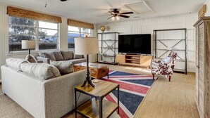 Ein Wohnzimmer mit Sofa, Couchtisch, Fernseher und Deckenventilator.