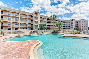 A hotel with a swimming pool, multiple balconies, and a palm tree. - 1 Block From the Beach, Next to Ft Clinch State Park and 2 Miles From Historic Centre Street (Fernandina Beach)