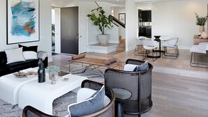 Un salon moderne avec un canapé blanc, une table basse et un coin repas comprenant une table et des chaises blanches.