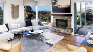 Un salon moderne avec un grand canapé, une cheminée et une vue sur l’extérieur.