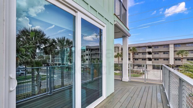 A balcony with a view of neighboring buildings and parked cars. - 391 South Fletcher A&B (Fernandina Beach)