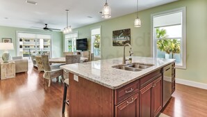 A spacious kitchen with a granite countertop, wooden cabinets, and a large island. - 391 South Fletcher A&B (Fernandina Beach)