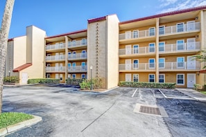 A multi-story hotel with balconies, a parking lot, and a clear sky. - 204 Atlantis (Fernandina Beach)