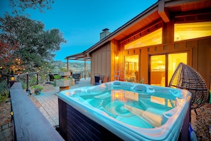 A hot tub in a backyard with a wooden deck and a house in the background. - 3046 Skycrest Drive (Fallbrook)