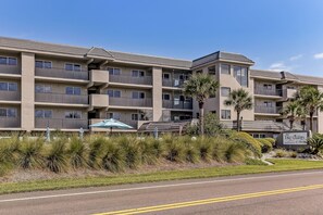 A multi-story hotel with balconies, a sign reading "The Oceans," and landscaped areas with plants and shrubs. - 314 Oceans of Amelia (Fernandina Beach)