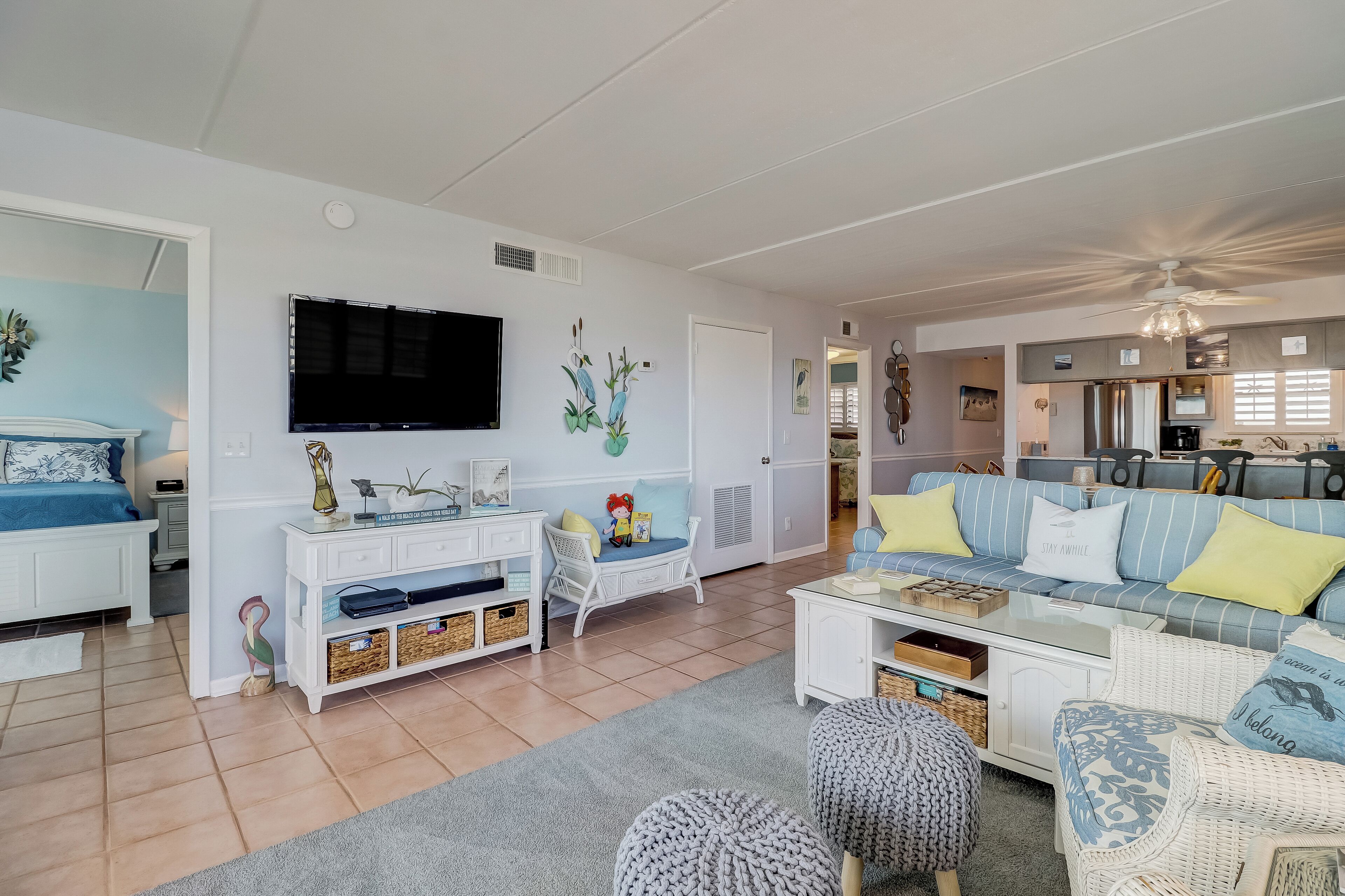 A spacious living room with a large TV, a sofa, and a dining area.