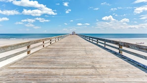 A wooden pier extending towards the beach with a railing on both sides. - 672 Amelia By The Sea (Fernandina Beach)
