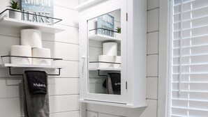 A modern bathroom with a white vanity, a sink, a toilet, and a window with blinds. - Pepper's Place 131 ITP (Dover)