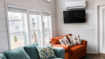 A living room with a teal sofa, an orange sofa, and a wooden coffee table.