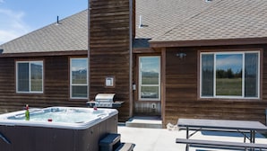 A wooden cabin with a hot tub, grill, and picnic table. - Teton Harmony (Driggs)
