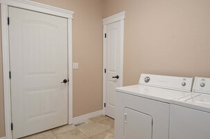 Un cuarto de lavandería con dos puertas blancas, una lavadora y una secadora.