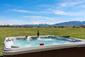 Ein Whirlpool in einer grünen Wiese mit Bergblick.