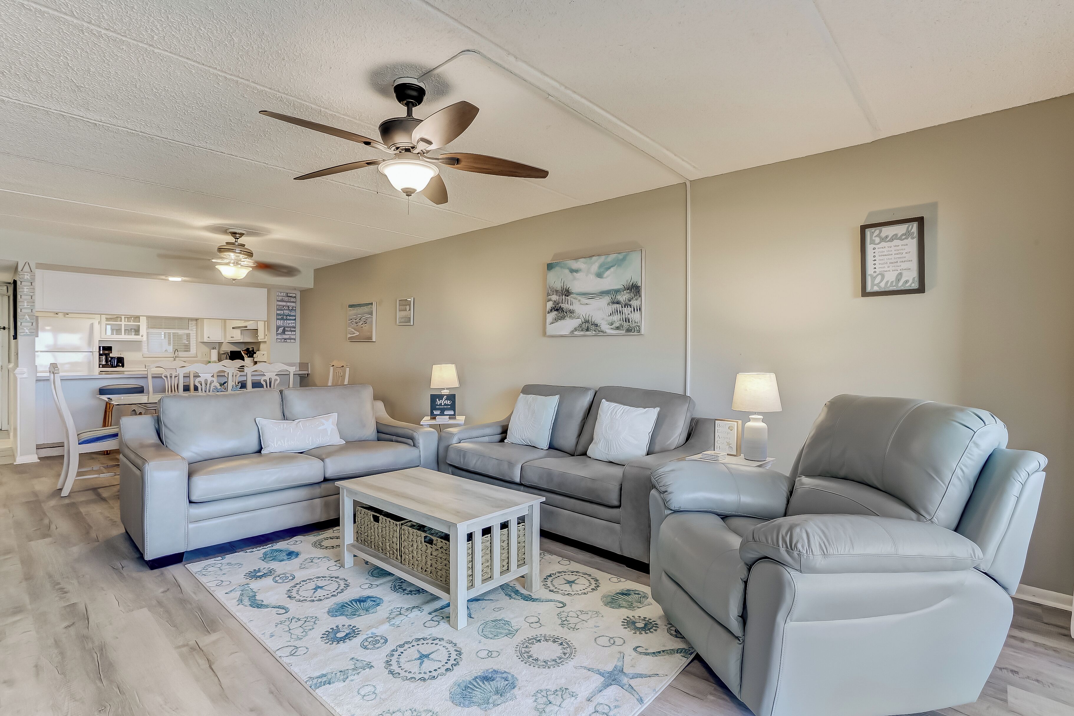 A modern living room with a grey sofa set, a coffee table, and a ceiling fan.