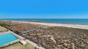 A beach view with a swimming pool and a pier. - C5 Amelia South (Fernandina Beach)