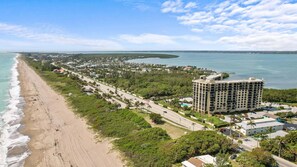 A coastal hotel with a beachfront view, multiple floors, and a parking area. - Ocean Drive Villas- Unit A (Fort Pierce)