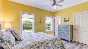 Une chambre à coucher avec un lit, une commode et un ventilateur de plafond.