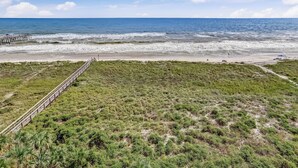 A coastal landscape with a beach, ocean, and a wooden pier. - M7 Amelia South (Fernandina Beach)