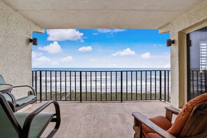 Ein Balkon mit Meerblick, ausgestattet mit Stühlen und einem Tisch.
