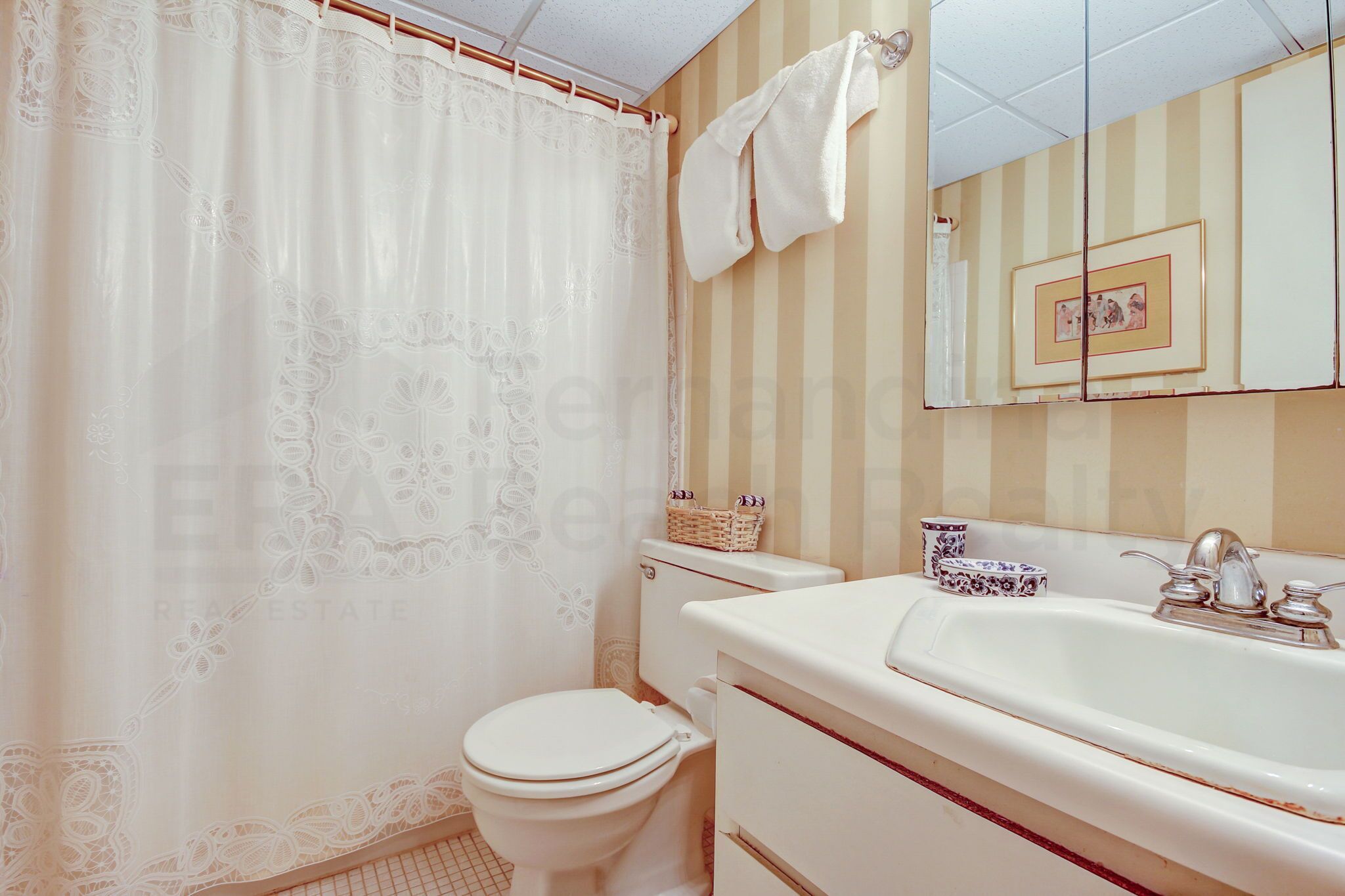 Ein Badezimmer mit Toilette, Waschbecken und einer Duschvorhang.