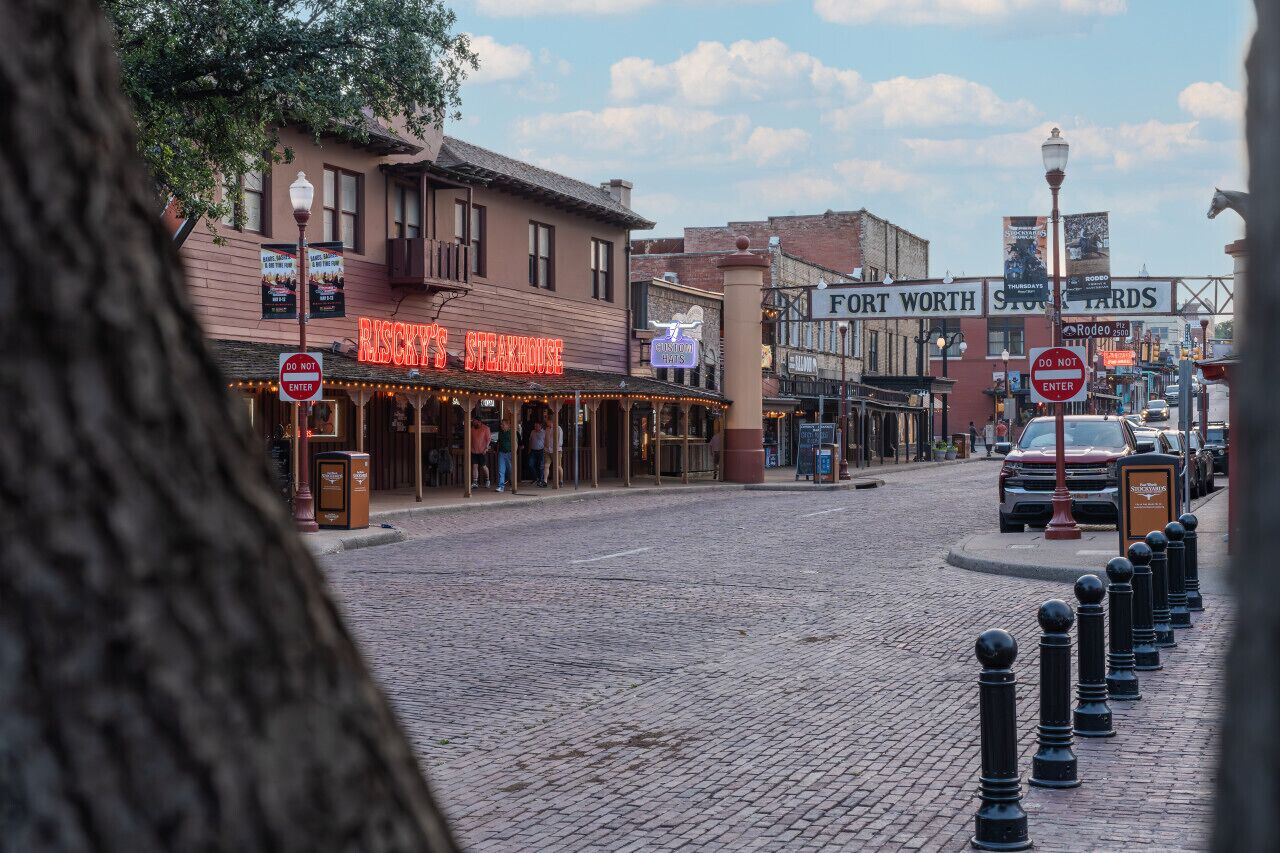 A historic street with buildings, including a steakhouse and a western-themed bar.