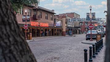 A historic street with buildings, including a steakhouse and a western-themed bar.